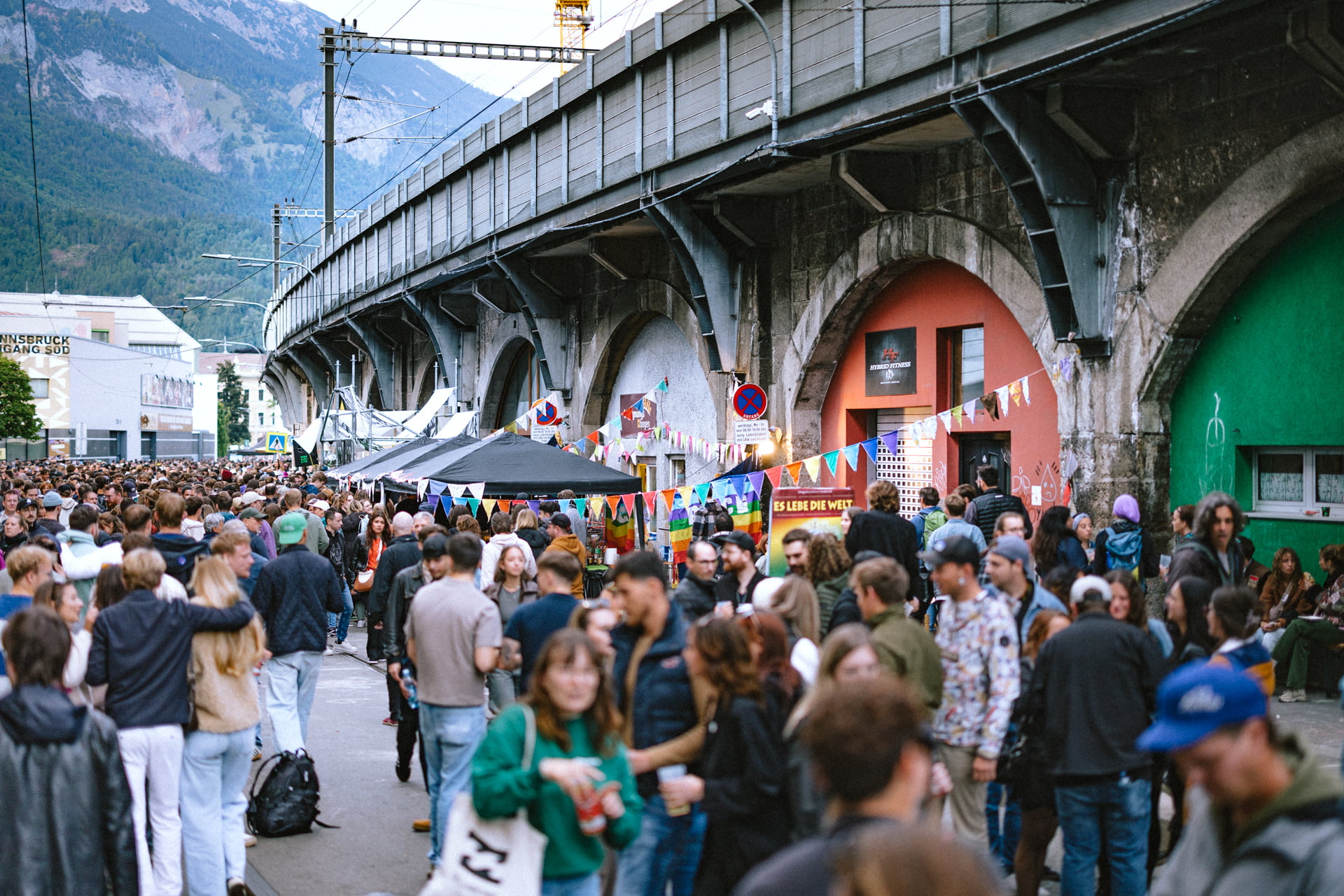 Menschenmenge auf der Bogenmeile in Innsbruck beim Bogenfest, bunte Dekoration und Straßenstände