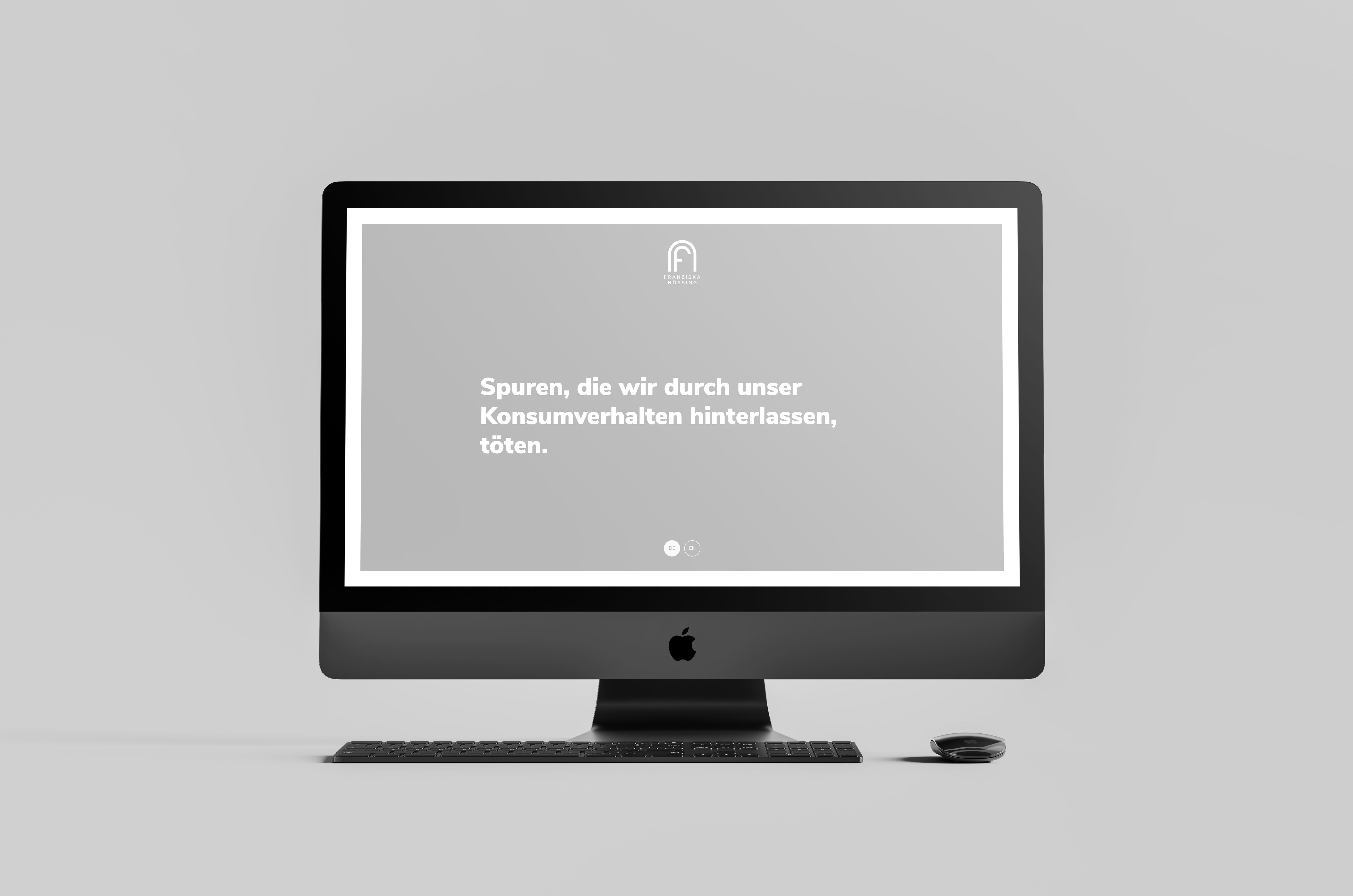 iMac auf hellgrauem Hintergrund mit Tastatur und Maus, der eine Website darstellt